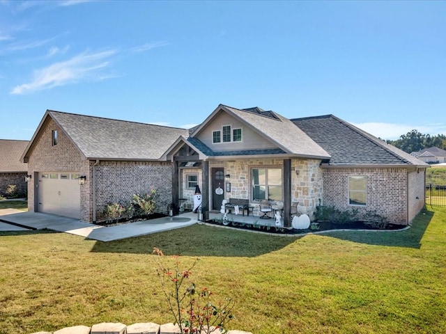 view of front of house with a garage, a porch, and a front yard