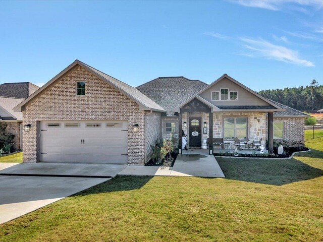 view of front of house featuring covered porch, a front yard, and a garage