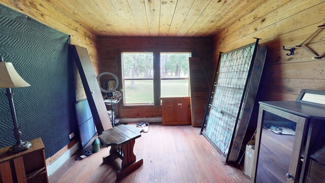 exercise room with light wood-type flooring, wooden walls, and wood ceiling