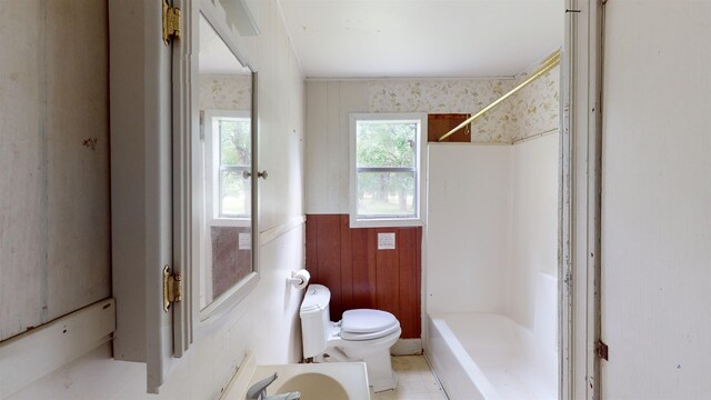 full bathroom featuring bathing tub / shower combination, wood walls, vanity, and toilet