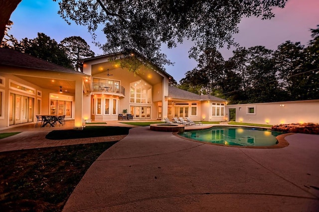 205 Twin Crk, Lufkin, TX 75904 - pool at dusk featuring a patio area, french doors, ceiling fan, and a pool with connected hot tub