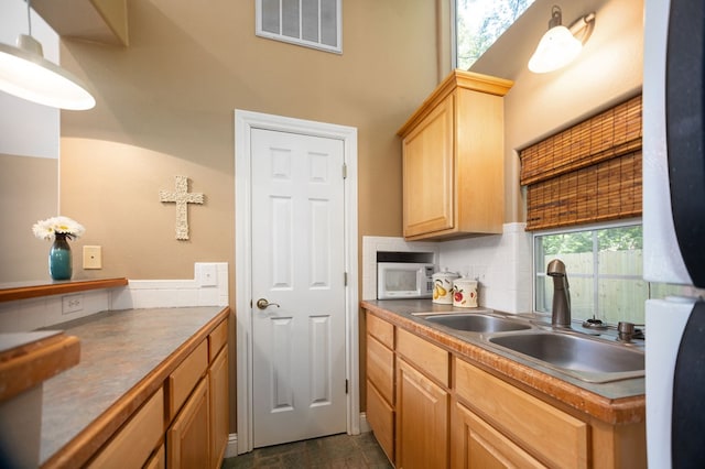 205 Twin Crk, Lufkin, TX 75904 - kitchen with white microwave, a sink, decorative backsplash, and light brown cabinets