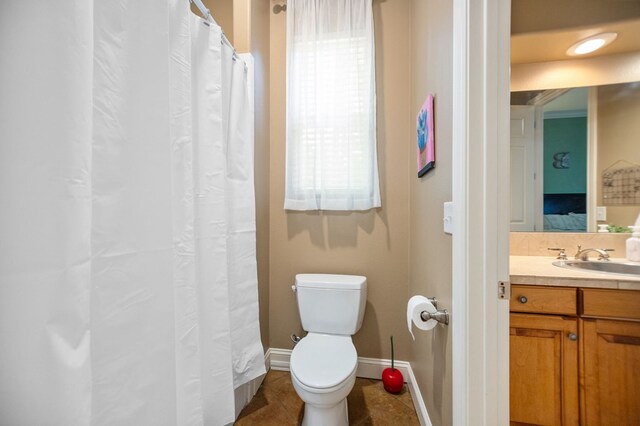 205 Twin Crk, Lufkin, TX 75904 - ensuite bathroom with toilet, baseboards, vanity, and tile patterned flooring