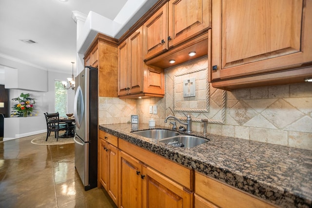 205 Twin Crk, Lufkin, TX 75904 - kitchen with freestanding refrigerator, a sink, ornamental molding, tasteful backsplash, and brown cabinets
