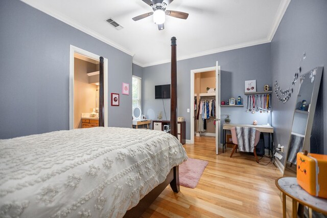 205 Twin Crk, Lufkin, TX 75904 - bedroom featuring a spacious closet, light wood-style flooring, crown molding, a closet, and a ceiling fan
