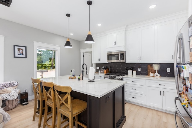 190 Whitehead Dr, Diboll, TX 75941 - kitchen featuring appliances with stainless steel finishes, light wood-style floors, decorative backsplash, white cabinets, and a sink