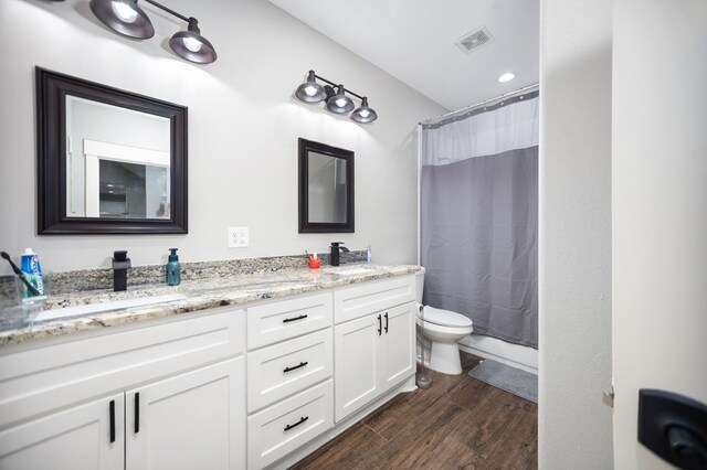 1065 Cc Rd, Diboll, TX 75941 - bathroom with toilet, double vanity, wood finished floors, and curtained shower