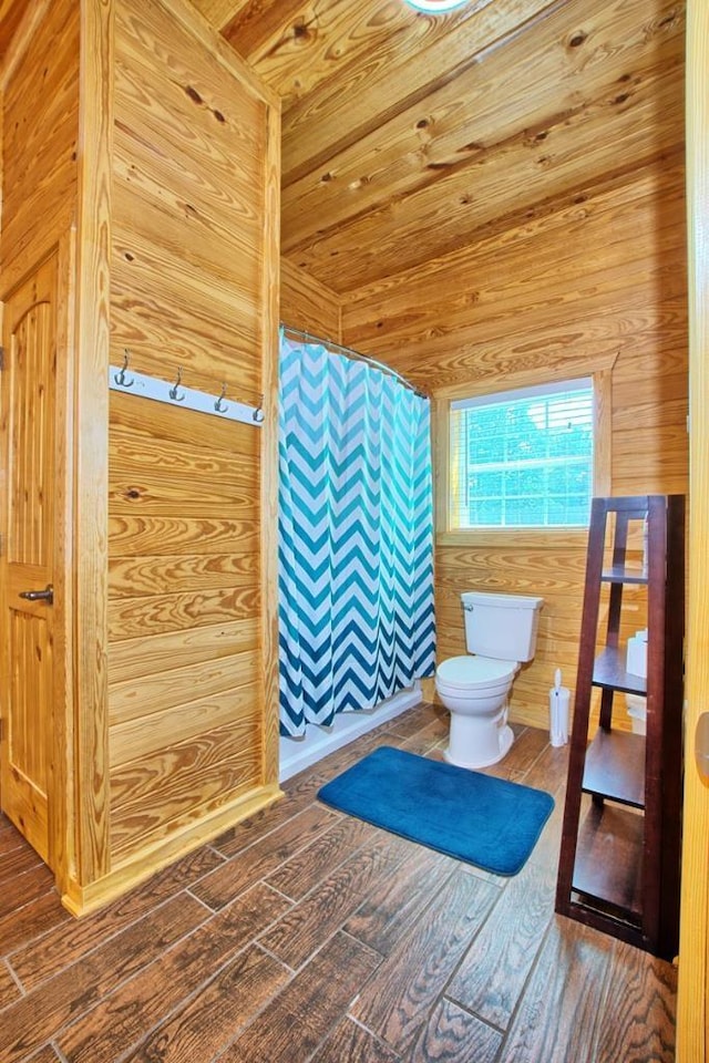 bathroom featuring curtained shower, wood walls, toilet, and hardwood / wood-style flooring