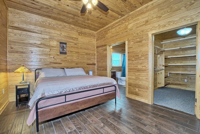 bedroom featuring ceiling fan, dark wood-type flooring, ensuite bathroom, wood walls, and wood ceiling