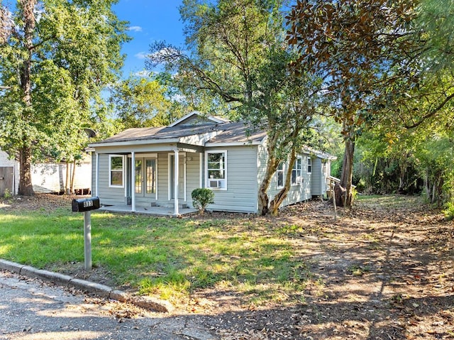 bungalow featuring covered porch and a front lawn