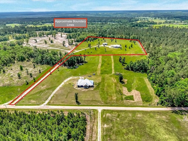birds eye view of property featuring a view of trees and a rural view