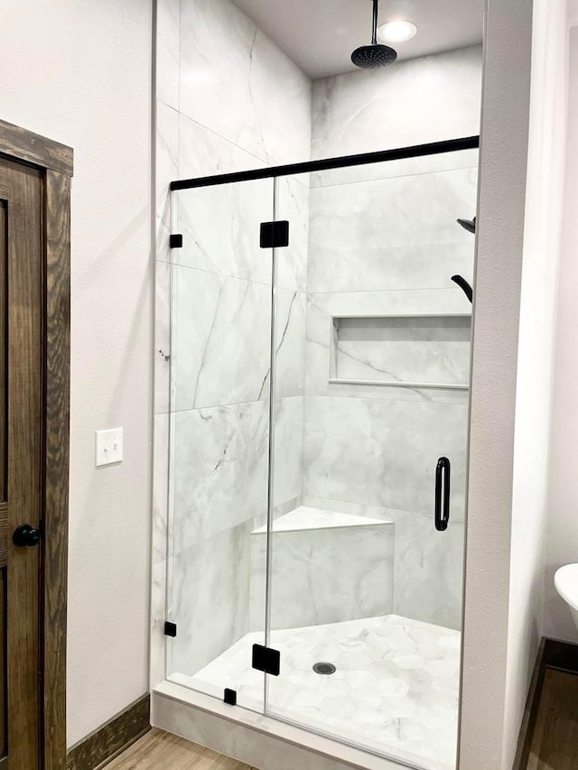 full bath featuring a shower stall and wood finished floors