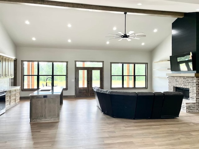 living area with light wood-style flooring, a brick fireplace, recessed lighting, and ceiling fan