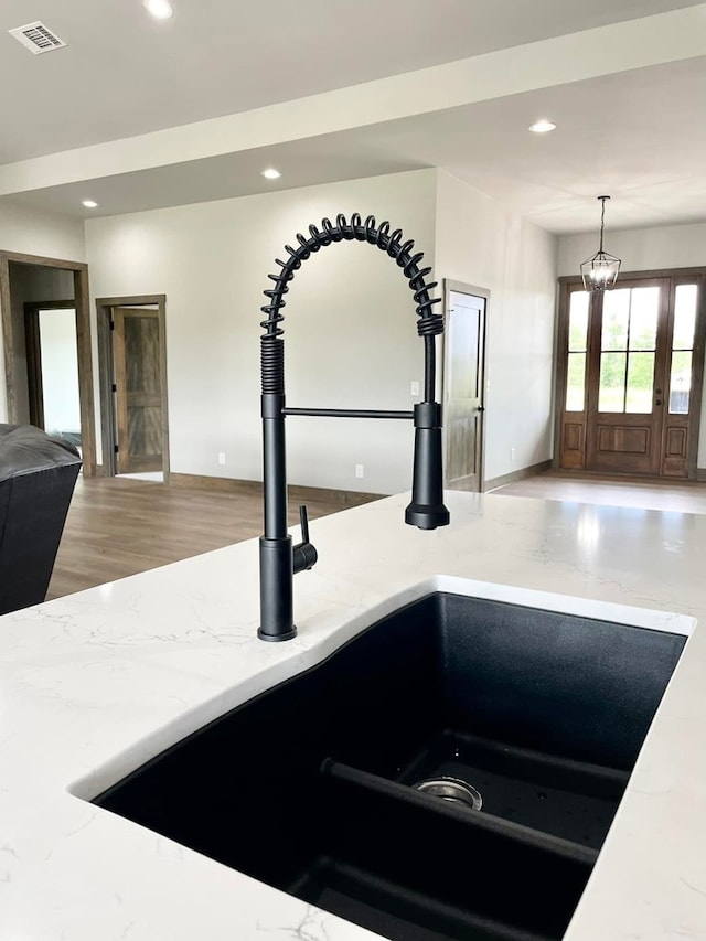 details with a sink, visible vents, recessed lighting, pendant lighting, and light stone counters