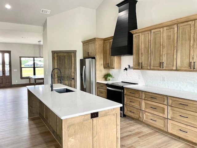 kitchen featuring a sink, light wood-type flooring, stainless steel fridge, electric range, and visible vents