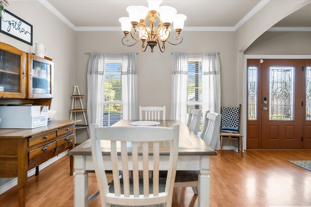 454 Bobwhite Dr, Lufkin, TX 74904 - dining space featuring light wood-style flooring, healthy amount of natural light, arched walkways, crown molding, and a chandelier