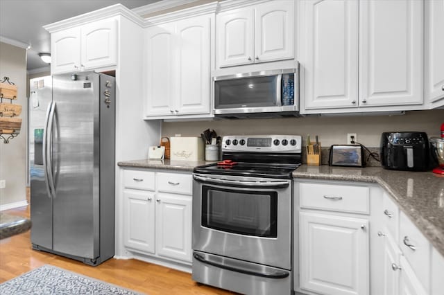 454 Bobwhite Dr, Lufkin, TX 74904 - kitchen featuring stainless steel appliances, light wood-type flooring, white cabinets, crown molding, and light stone counters