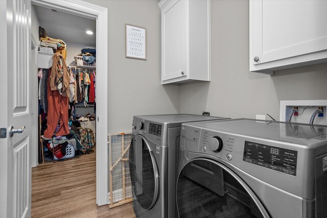 1755 Cc Rd, Diboll, TX 75941 - laundry area featuring cabinet space, washer and dryer, and light wood-style flooring