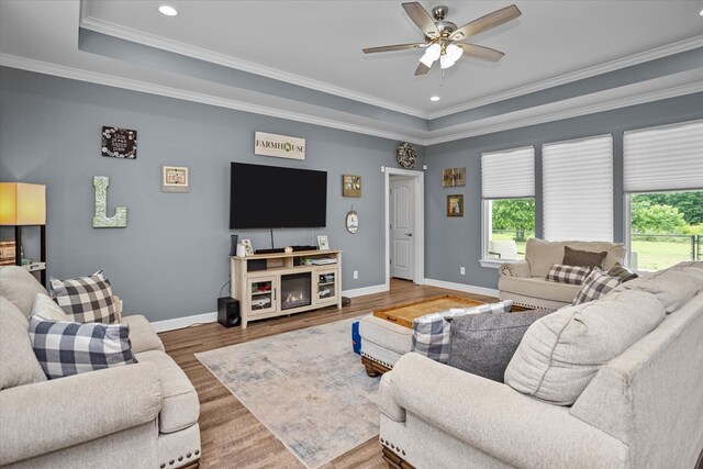 1755 Cc Rd, Diboll, TX 75941 - living area featuring healthy amount of natural light, wood finished floors, ceiling fan, a tray ceiling, and crown molding