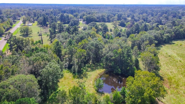 aerial view featuring a wooded view and a water view