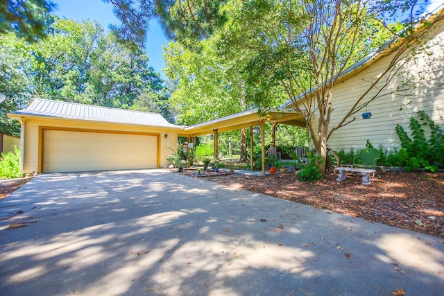 view of front of house featuring an attached garage, driveway, and metal roof