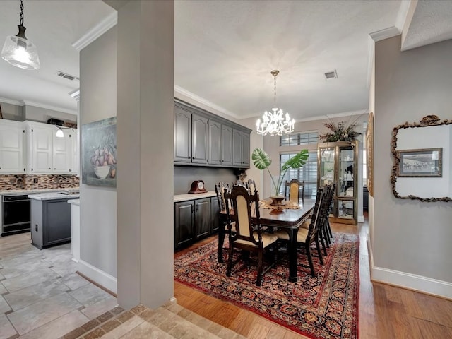 dining room featuring an inviting chandelier, light hardwood / wood-style flooring, and crown molding