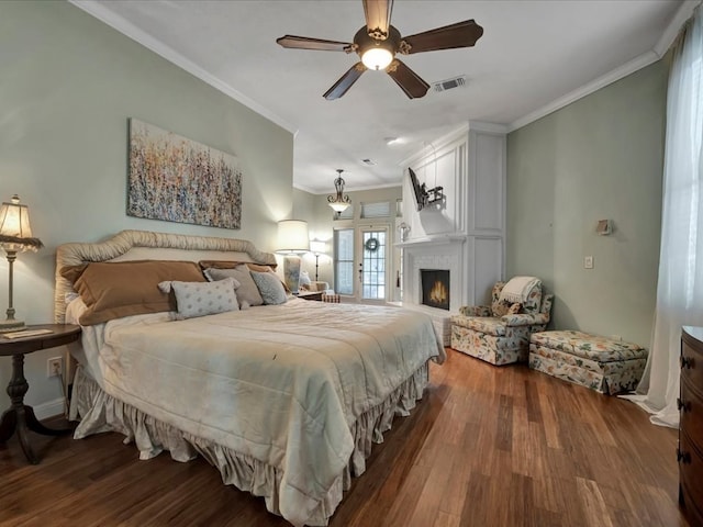 bedroom with dark hardwood / wood-style flooring, ceiling fan, and crown molding