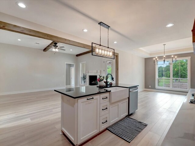 234 Lancewood Dr, Lufkin, TX 75904 - kitchen featuring open floor plan, dark countertops, light wood-style floors, white cabinetry, and a kitchen island with sink