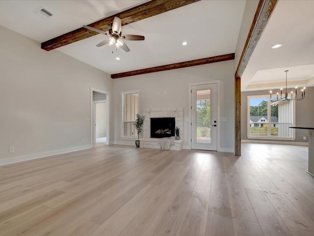234 Lancewood Dr, Lufkin, TX 75904 - unfurnished living room featuring a chandelier, beam ceiling, a ceiling fan, a high end fireplace, and light wood finished floors