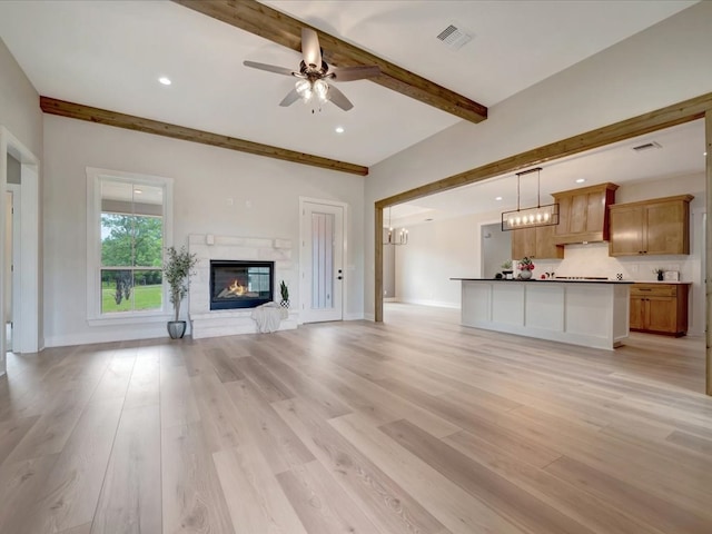 234 Lancewood Dr, Lufkin, TX 75904 - unfurnished living room featuring beamed ceiling, a ceiling fan, light wood finished floors, a glass covered fireplace, and recessed lighting