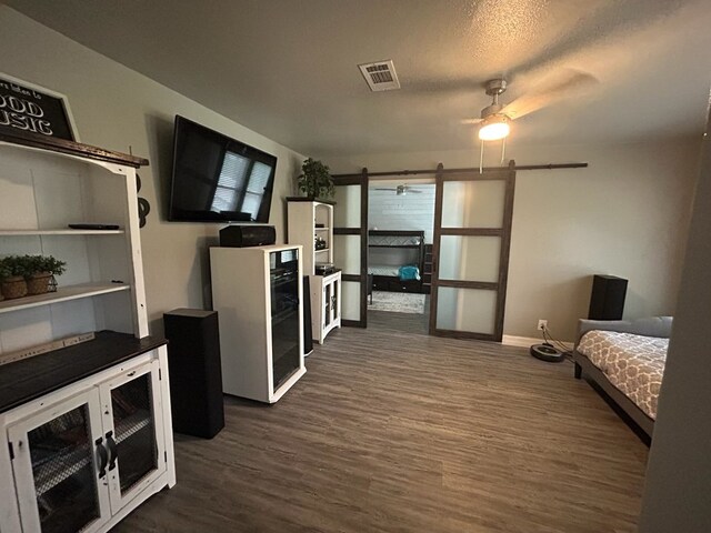 270 Lakeshore Dr, Brookeland, TX 75931 - kitchen with a barn door, dark wood finished floors, ceiling fan, and dark countertops