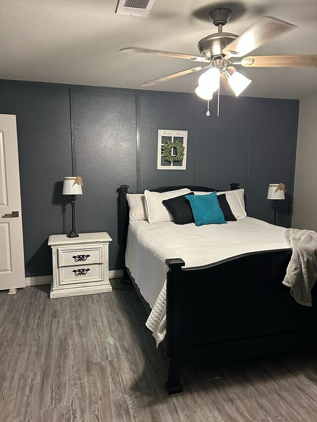 270 Lakeshore Dr, Brookeland, TX 75931 - bedroom featuring wood finished floors, a ceiling fan, and a decorative wall