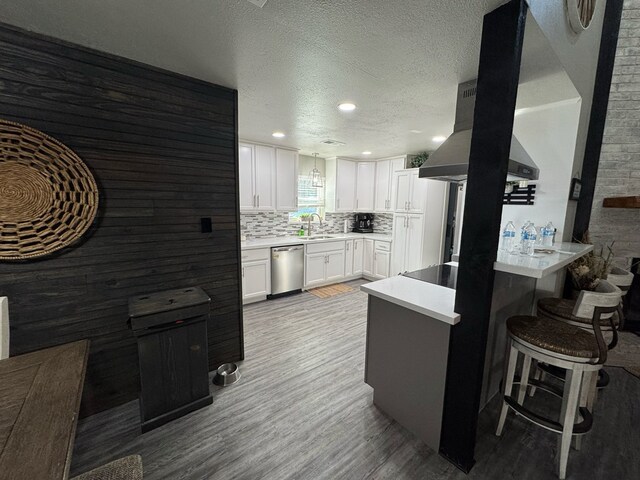 270 Lakeshore Dr, Brookeland, TX 75931 - kitchen featuring stainless steel dishwasher, wood finished floors, white cabinets, a peninsula, and a textured ceiling