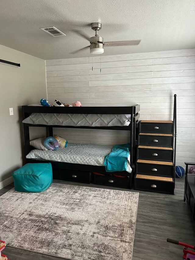 270 Lakeshore Dr, Brookeland, TX 75931 - bedroom featuring wood walls, wood finished floors, a textured ceiling, and ceiling fan