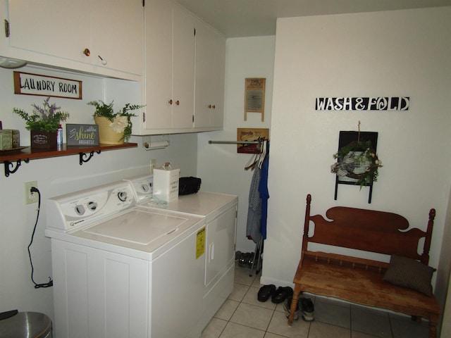 laundry area with washer and clothes dryer, light tile patterned flooring, and cabinets