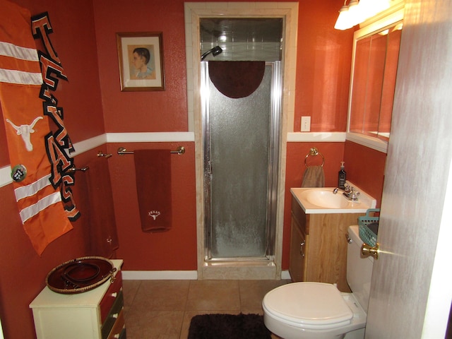 bathroom with tile patterned flooring, vanity, toilet, and walk in shower