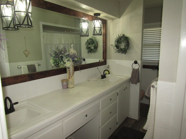 bathroom with hardwood / wood-style floors, vanity, a chandelier, and toilet