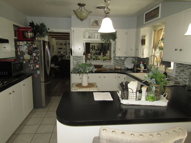 kitchen featuring decorative light fixtures, white cabinetry, appliances with stainless steel finishes, and tasteful backsplash