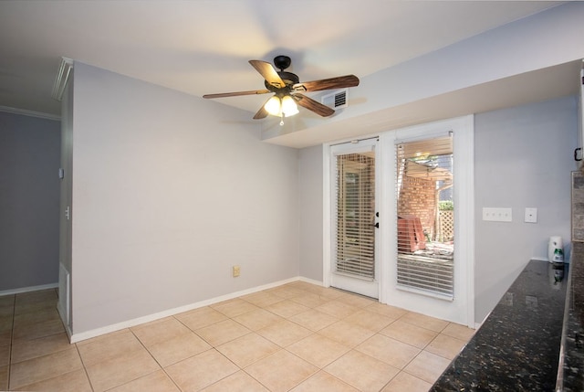 spare room featuring ceiling fan, light tile patterned flooring, and crown molding