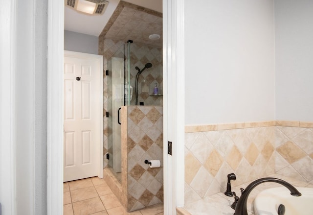 bathroom featuring tile patterned floors, plus walk in shower, and tile walls