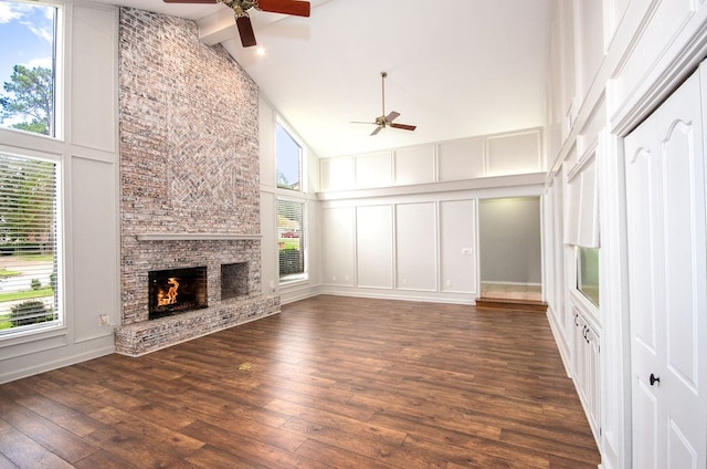 unfurnished living room featuring ceiling fan, a large fireplace, high vaulted ceiling, and dark hardwood / wood-style floors