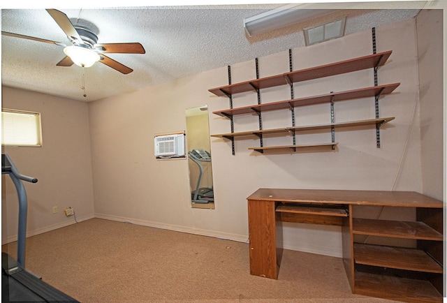 basement with a wall mounted air conditioner, a textured ceiling, light colored carpet, and ceiling fan