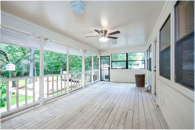 unfurnished sunroom with ceiling fan