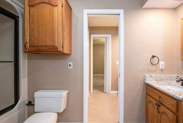 bathroom with tile patterned flooring, vanity, and toilet