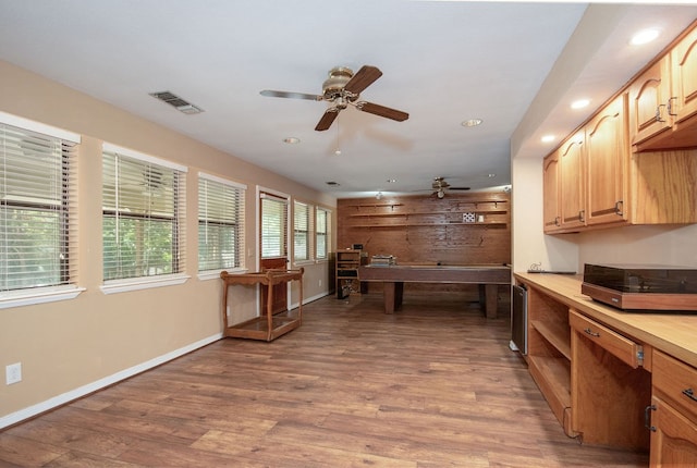 kitchen with ceiling fan, light brown cabinetry, and hardwood / wood-style flooring