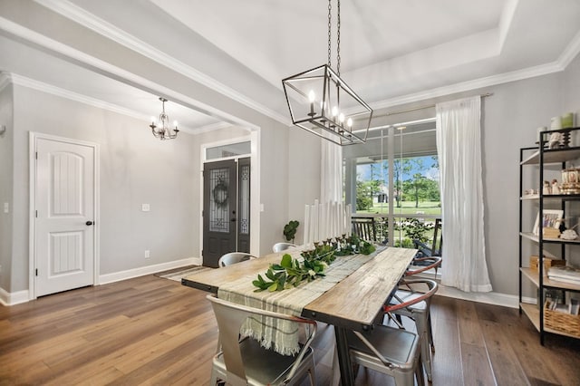 dining space featuring wood-type flooring, an inviting chandelier, crown molding, and baseboards