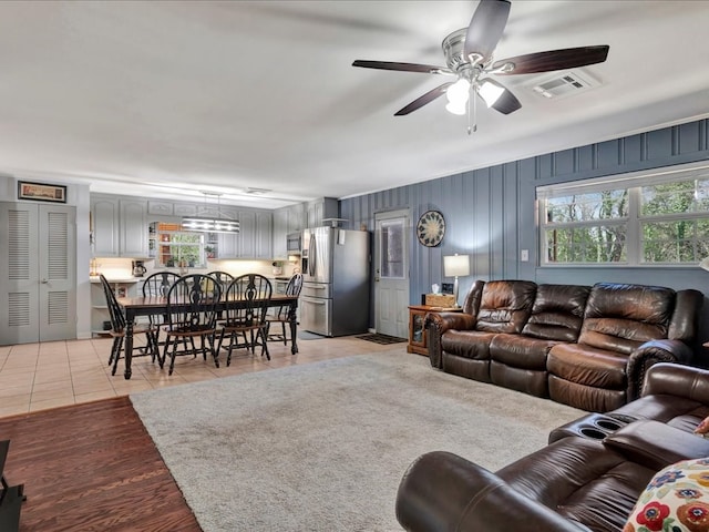 living area featuring visible vents, ceiling fan, and light tile patterned floors