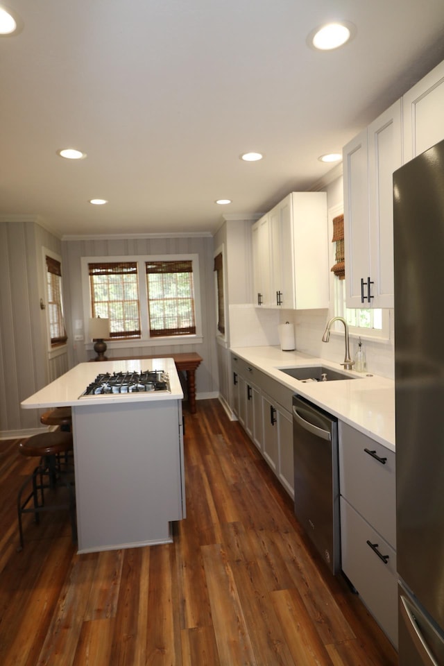 kitchen with a center island, white cabinets, sink, dark hardwood / wood-style flooring, and stainless steel appliances