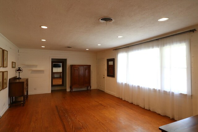 unfurnished living room featuring a textured ceiling and hardwood / wood-style flooring