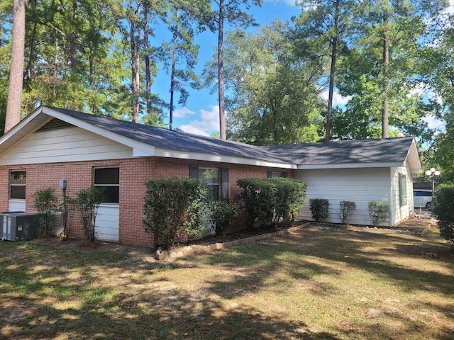 rear view of house featuring central AC unit and a yard